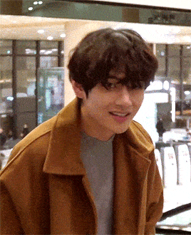 kim taehyung in brown coat bowing to korean reporters